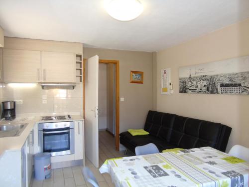 une cuisine et un salon avec un canapé dans l'établissement Charmant Appartement 2 Pièces avec Balcon et Parking à Châtel - Idéal pour 4 Personnes - FR-1-198-141, à Châtel