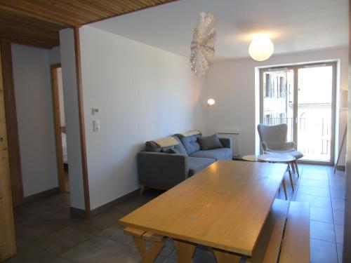 un salon avec une table et un canapé dans l'établissement Confort et modernité: Appartement 60m² pour 4 personnes avec balcon, WIFI, proche du centre et pistes. - FR-1-198-164, à Châtel