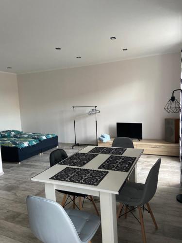 um quarto com uma mesa e cadeiras e uma cama em Apartamenty Bezrzecze em Szczecin