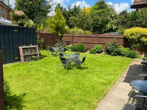 a yard with tables and chairs on the grass at Fairlawns Guest House in Banbury