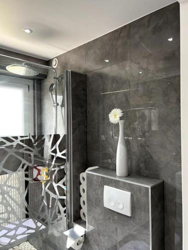 La salle de bains est pourvue d'un vase avec une fleur. dans l'établissement Superbe appartement lumineux avec parking gratuit, à Wintzenheim