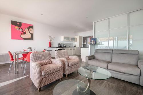 un salon avec un canapé, des chaises et une table dans l'établissement Plage du Nau, vue mer, bel appartement pour 6, au Pouliguen
