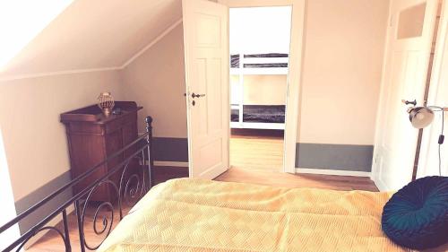 a bedroom with a bed and a doorway to a closet at Villa Weißbach - Haus Hilda in Flöha