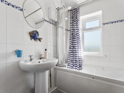 a white bathroom with a sink and a mirror at Pass the Keys Spacious 4 bed house overlooking Borth Beach in Borth