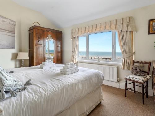 a bedroom with a bed and a window with the ocean at Pass the Keys Spacious 4 bed house overlooking Borth Beach in Borth