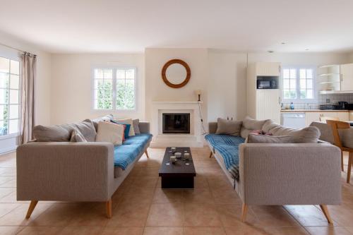 un salon avec deux canapés et une table dans l'établissement Belle maison proche de la mer pour 6 personnes, à Notre-Dame-de-Monts