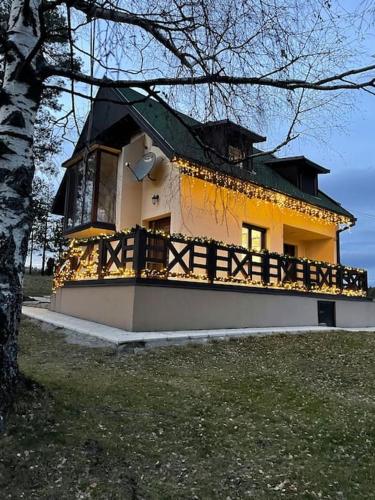 a yellow and white house with a black roof at Maison ALANA in Divčibare