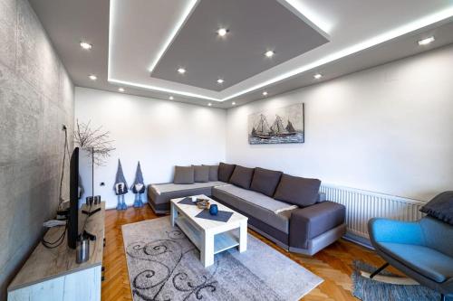 a living room with a couch and a table at Maison ALANA in Divčibare