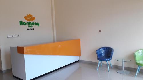 a waiting room with two chairs and a sign on the wall at Harmony Inn Belitung - City Hotel in Tanjungpandan