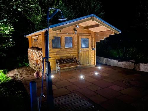 a small shed with a bench on a patio at night at RelaxHotel Tannenhof in Sasbachwalden