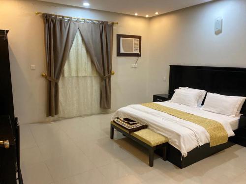 Un dormitorio con una cama grande y una ventana en بيوتات الزير, en Al Bahah