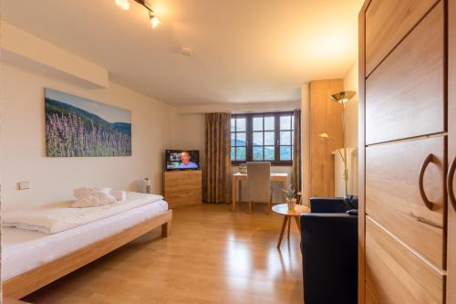 ザスバッハヴァルデンにあるRelaxHotel Tannenhofのベッドとテーブルが備わるホテルルームです。