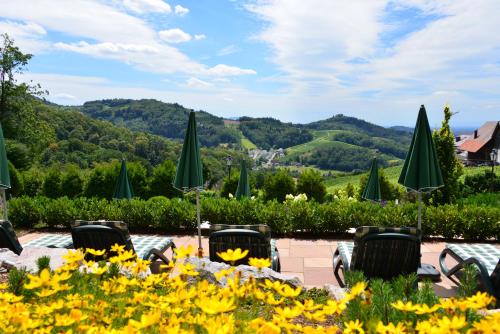a table with chairs and umbrellas and flowers at RelaxHotel Tannenhof in Sasbachwalden