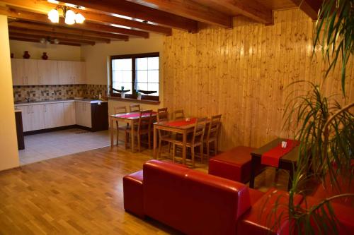 a living room with a table and chairs and a kitchen at Nad Stawem in Powidz