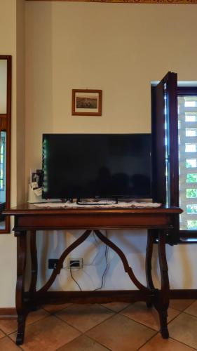 a desk with a keyboard and a monitor on it at Rovere dalla riva in Arzene