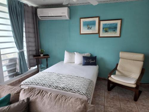 a blue bedroom with a bed and a chair at Playa Azul II 302 in Luquillo