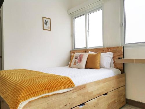 a bedroom with a wooden bed with two windows at Precioso Apartamento D in Guatemala