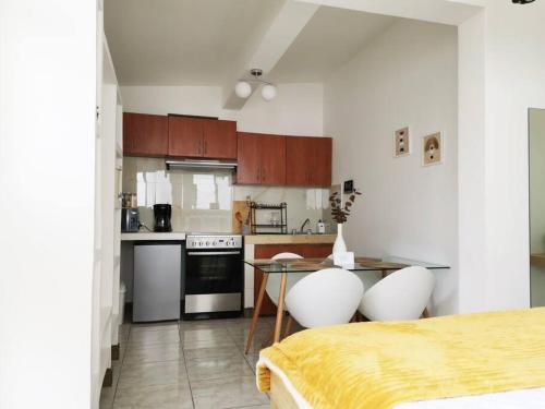 a kitchen with a table and two white chairs at Precioso Apartamento D in Guatemala