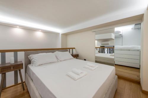 1 dormitorio con 1 cama blanca grande y espejo en FCM Tourism - Rosales Studio, en Milán