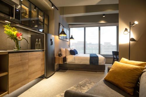 Habitación de hotel con cama y sofá en Unique Mine - Luxury Lofts with Pool - Gym - Cowork, en Bogotá