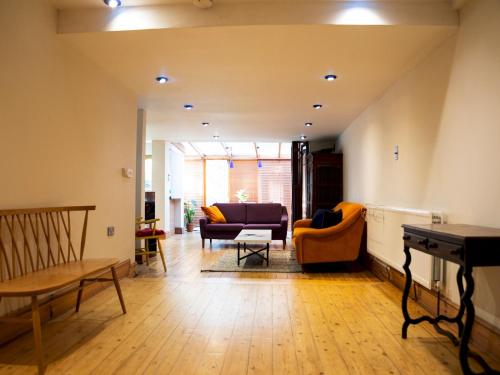 a living room with a couch and a table at Pass the Keys Funky Garden House in Chiswick in London