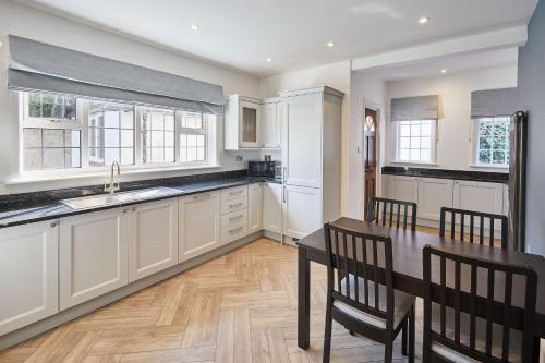 a kitchen with white cabinets and a table and chairs at Host & Stay - White Lodge in Scalby