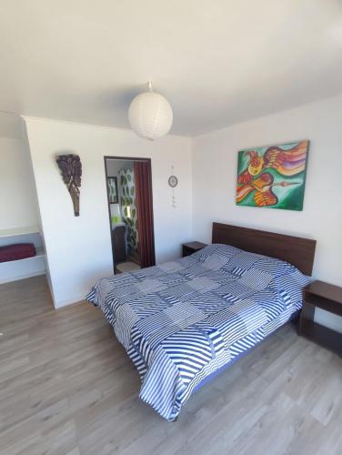 a bedroom with a bed with a blue and white comforter at La Tribu Ecolodge y Camping in Algarrobo