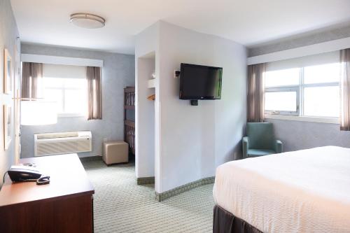 a hotel room with a bed and a flat screen tv at Rodd Moncton in Moncton