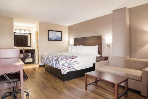 Pokój hotelowy z łóżkiem i biurkiem w obiekcie Red Roof Inn Baltimore South Glen Burnie w mieście Glen Burnie