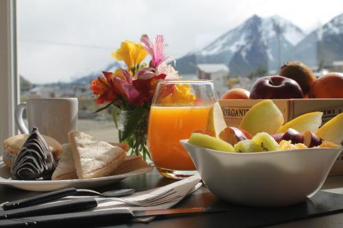 Comarca Fueguina في أوشوايا: طاولة مع وعاء من الفاكهة وكأس من عصير البرتقال