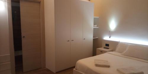 een witte slaapkamer met een bed en een witte kast bij Agriturismo Le Valli in Liedolo