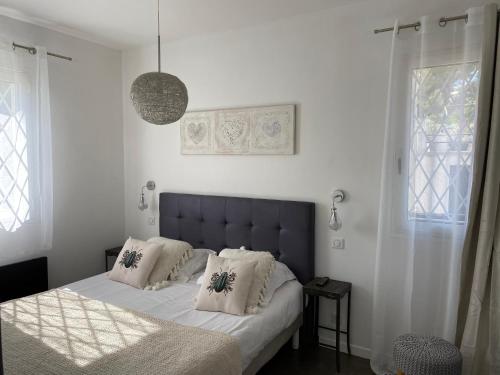 a bedroom with a bed with white sheets and pillows at Villa W in Cassis