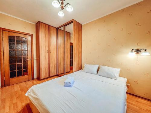 1 dormitorio con 1 cama blanca grande en una habitación en Apartments near the Exhibition Centre en Kiev