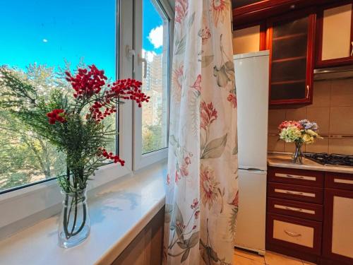 a vase of flowers on a counter in a kitchen at Apartments near the Exhibition Centre in Kyiv