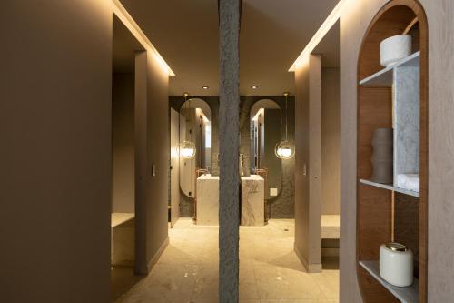 a hallway of a bathroom with mirrors and sinks at Unique Mine - Luxury Lofts with Pool - Gym - Cowork in Bogotá