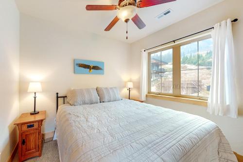 een slaapkamer met een bed, een plafondventilator en een raam bij Soaring Eagle in Sandpoint