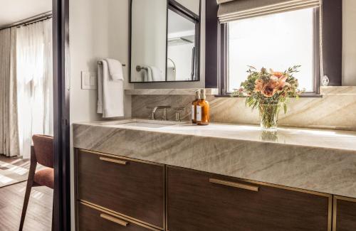 a bathroom with a sink and a vase of flowers at Orli La Jolla in San Diego