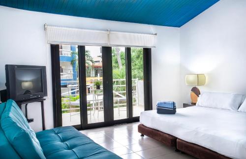 1 dormitorio con 1 cama, TV y sofá en Santorini Villas Santa Marta, en Santa Marta