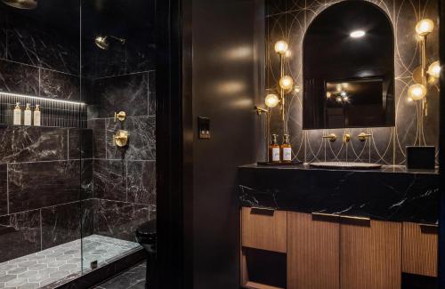 a black bathroom with a shower and a mirror at Orli La Jolla in San Diego