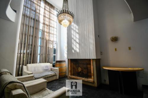a living room with a fireplace and a chandelier at Panda Hostel Mendoza in Mendoza