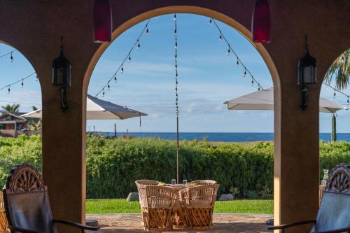 a patio with a table and chairs and the ocean at Villa Santa Cruz in Todos Santos