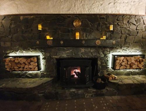 a large stone fireplace with logs in it at The Inn At Lathones in St. Andrews