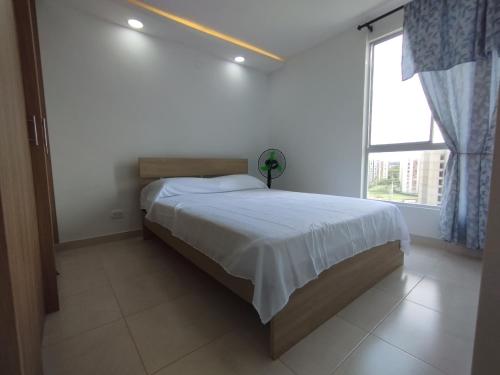 a bedroom with a bed and a large window at Hermoso Apartamento Estancia Tranquila por dias, semanas o meses in Jamundí