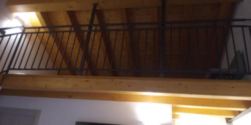 a wooden staircase with a metal railing on a ceiling at Agriturismo Le Valli in Liedolo