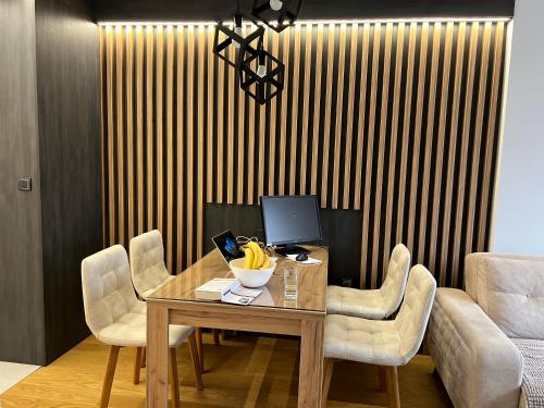a wooden table with chairs and a computer on it at Stan na dan Lorena in Sarajevo