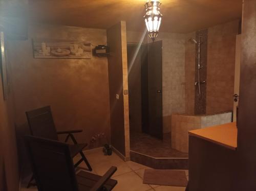 ein Bad mit einer Dusche, einem Schreibtisch und einem Stuhl in der Unterkunft Chambre d'hôte avec Hammam et salle de jeux in Chazelles-sur-Lyon