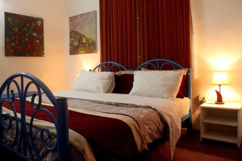 a bedroom with a bed with a red curtain at The Blue House "Gerasa" in Jerash