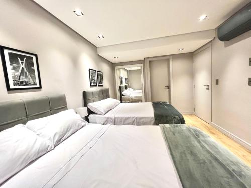um quarto de hotel com duas camas e um sidx sidx sidx azeb em Flat novo, 2 quartos, garagem no coração dos Jardins em São Paulo