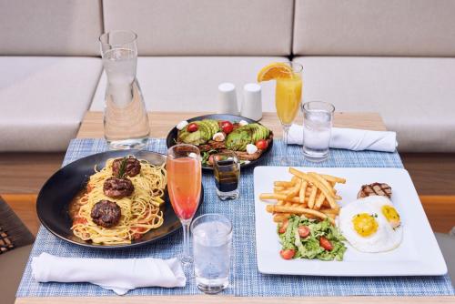 a table with a plate of food and a plate of pasta at Riu Plaza New York Times Square in New York