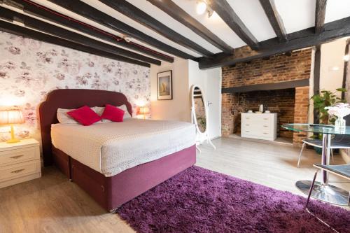 um quarto com uma cama e uma parede de tijolos em Pavilion Orpington em Foots Cray
